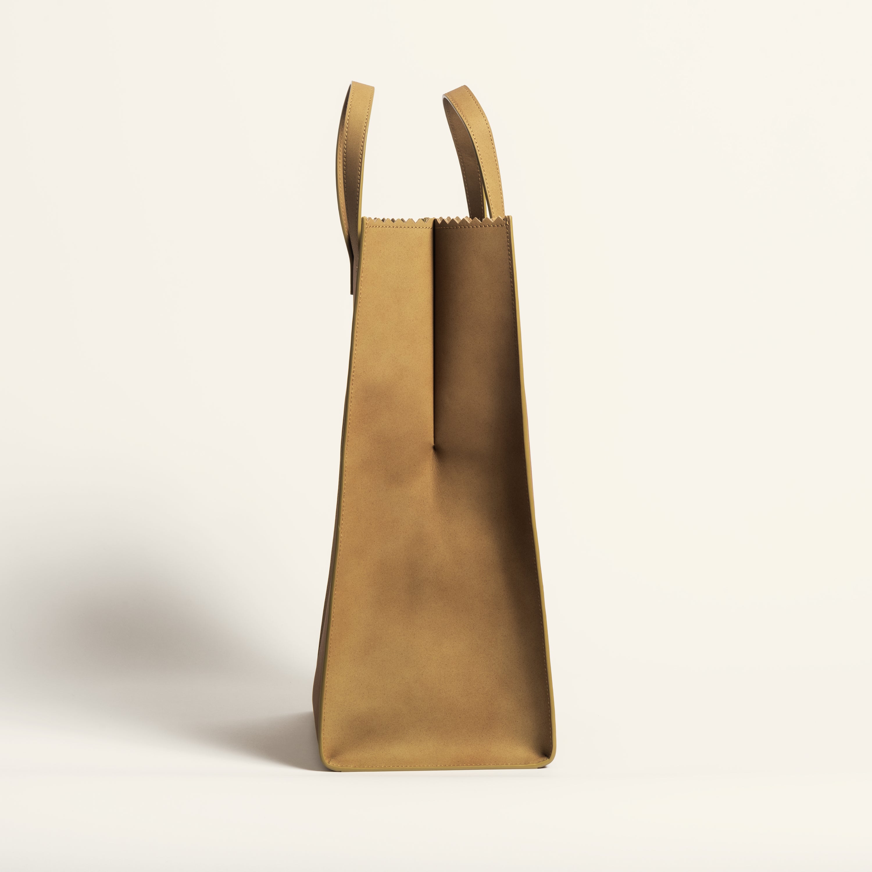 Kami tote bag by bukuro. A leather paper grocery bag side view on white backdrop.