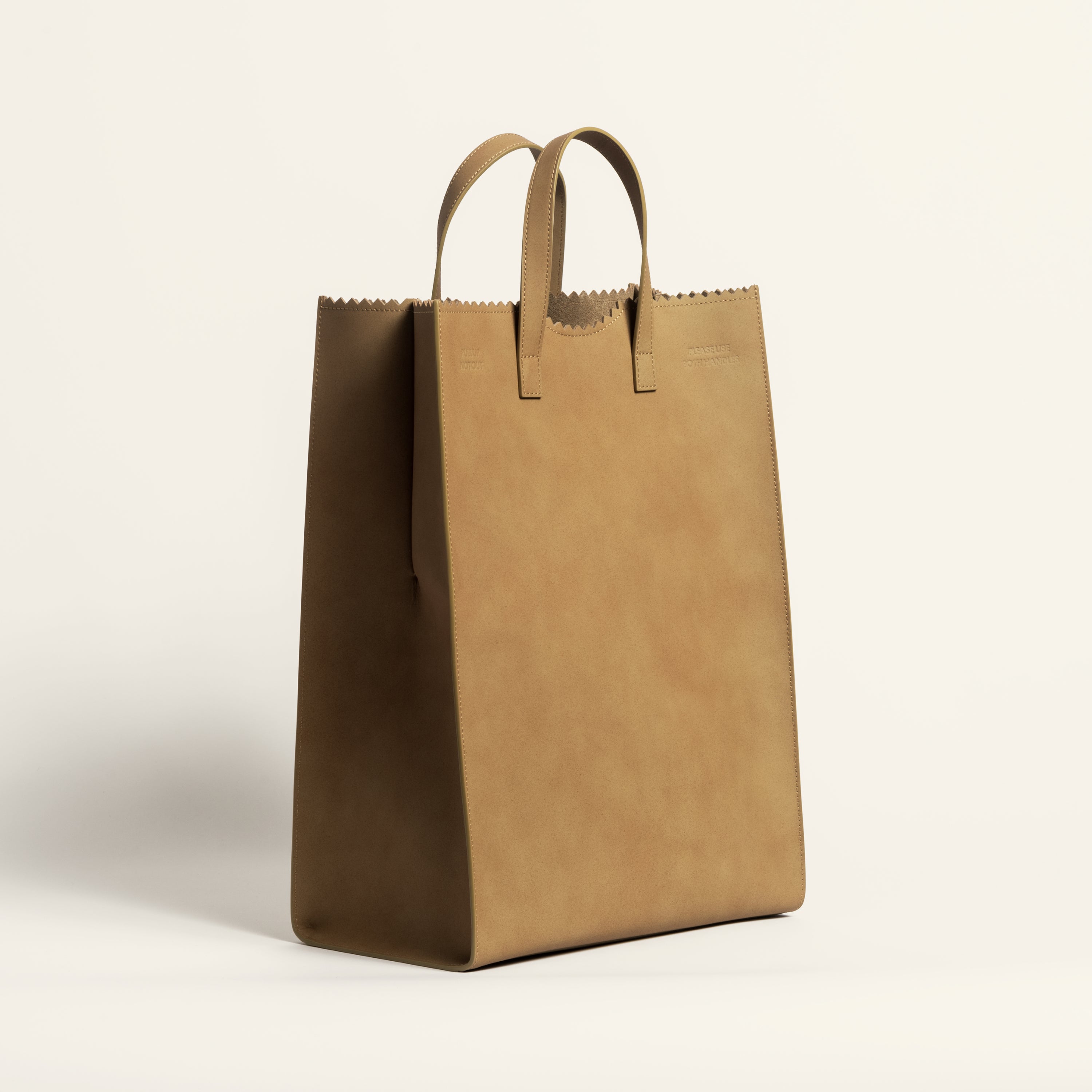 Kami tote bag by bukuro. A leather paper grocery bag 3/4 view on white backdrop.