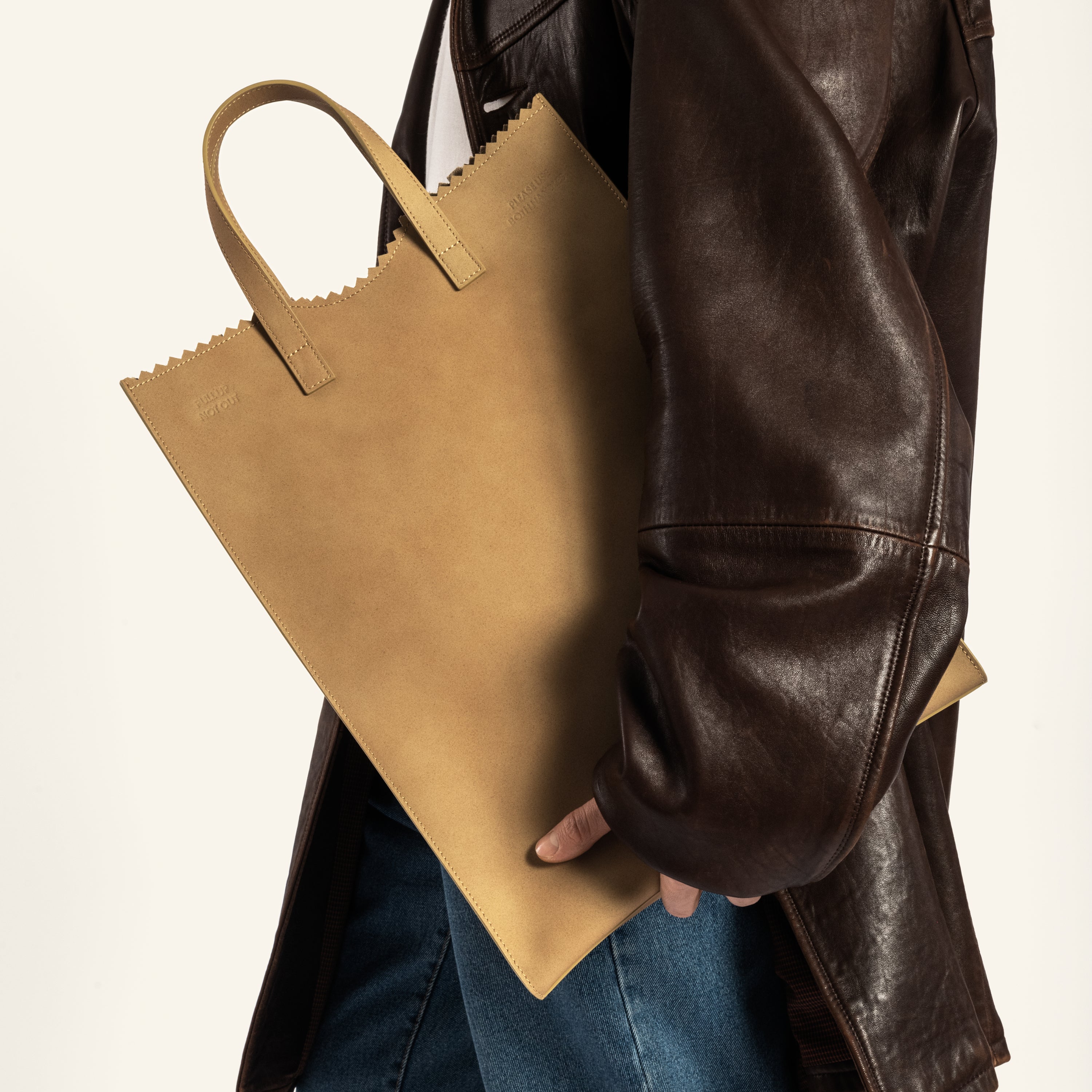 Japanese male model holding Kami tote bag by bukuro. A leather paper grocery bag held by a Japanese male model.