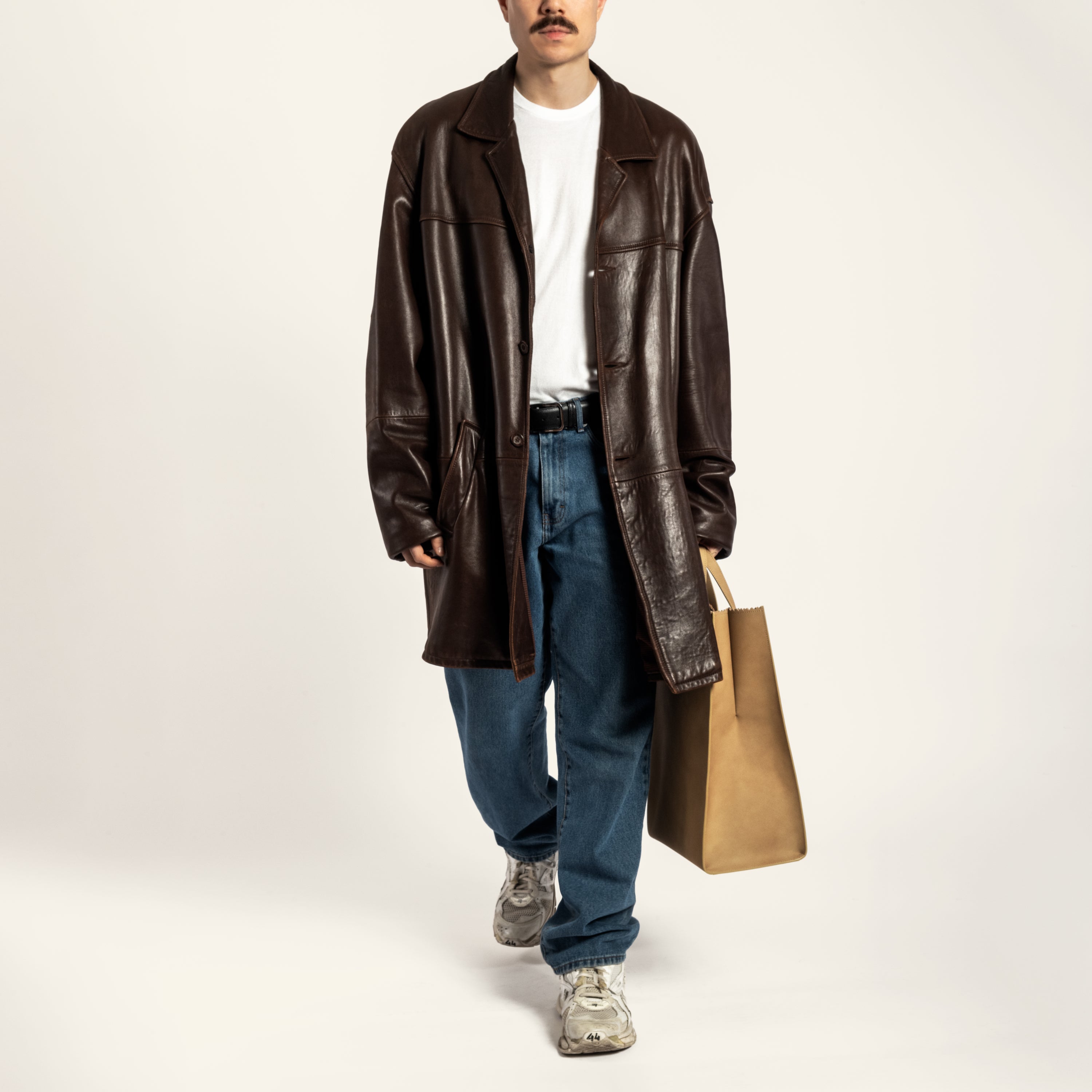 Japanese male model holding Kami tote bag by bukuro. A leather paper grocery bag held by a Japanese male model.